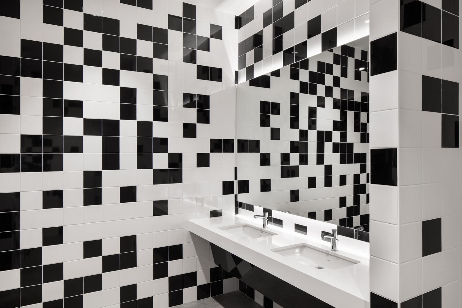 bathroom sink in OCAD U CO with black and white pixelated wall tiles