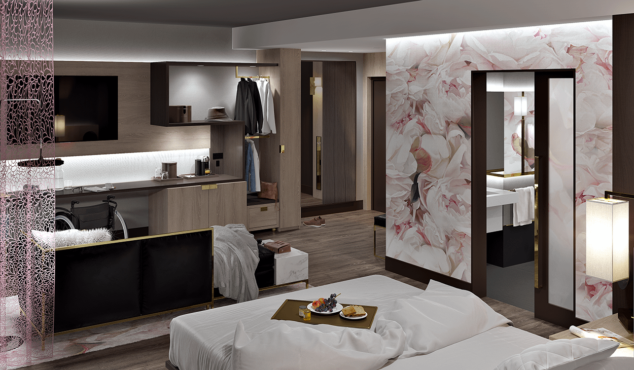 rendering of a hotel suite viewed from above the bed's headboard, showing a modular wall unit with lowered clothesrack, wheelchair at the desk, pink floral wallpaper and brass details
