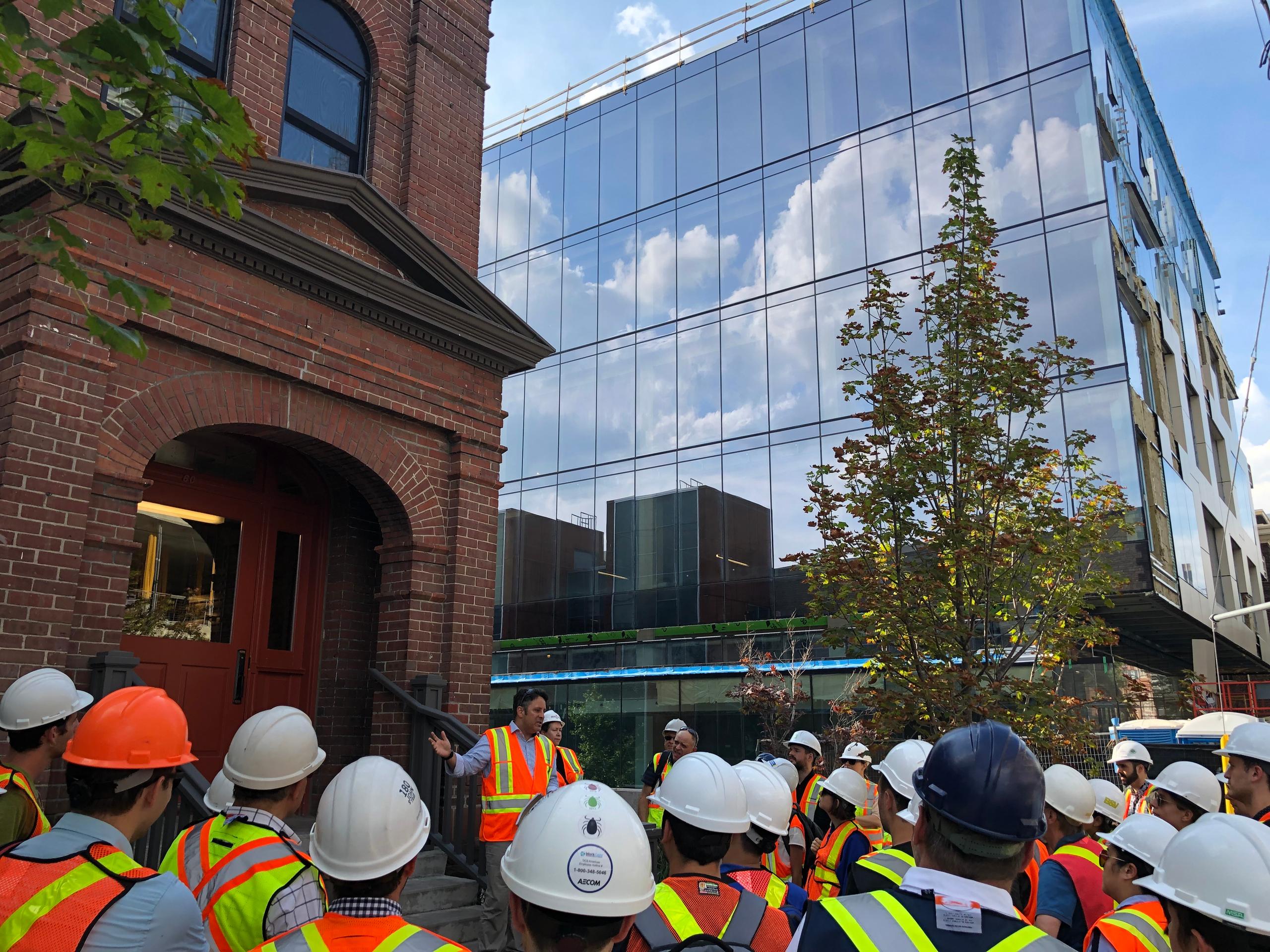 Richard Witt about to lead a tour of mass timber commercial building 80 Atlantic to architecture enthusiasts, with the fully glazed south facade in the background