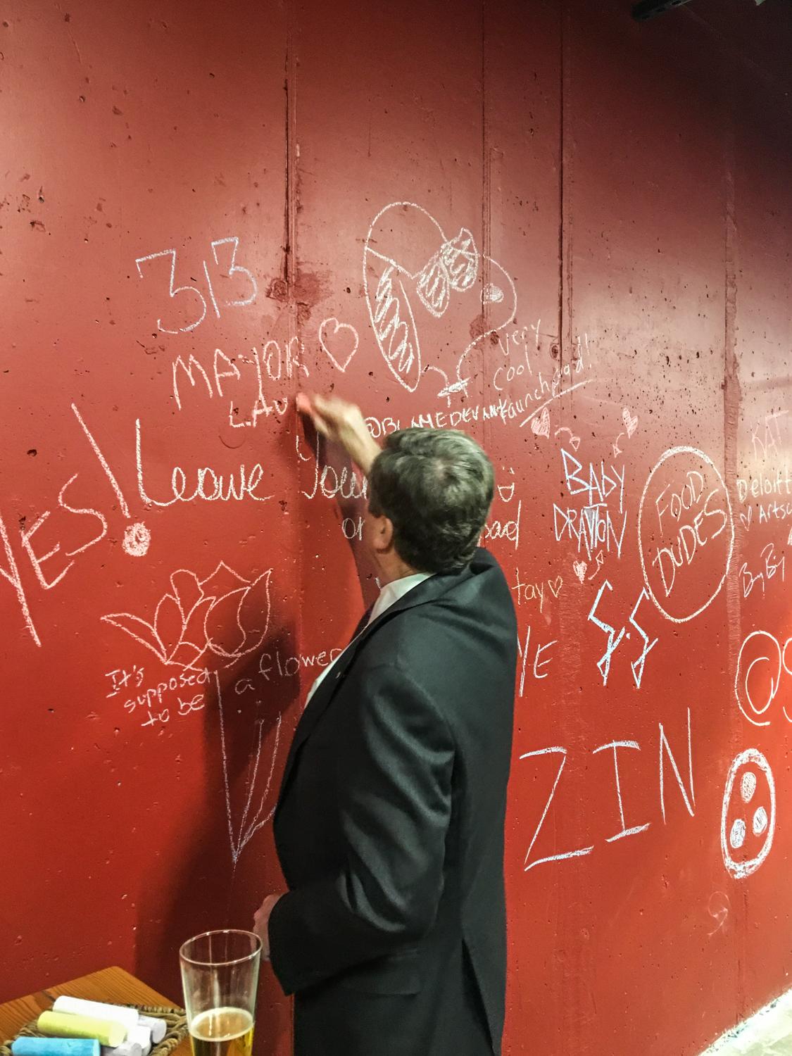 Mayor John Tory tags a red wall in Artscape Daniels Launchpad