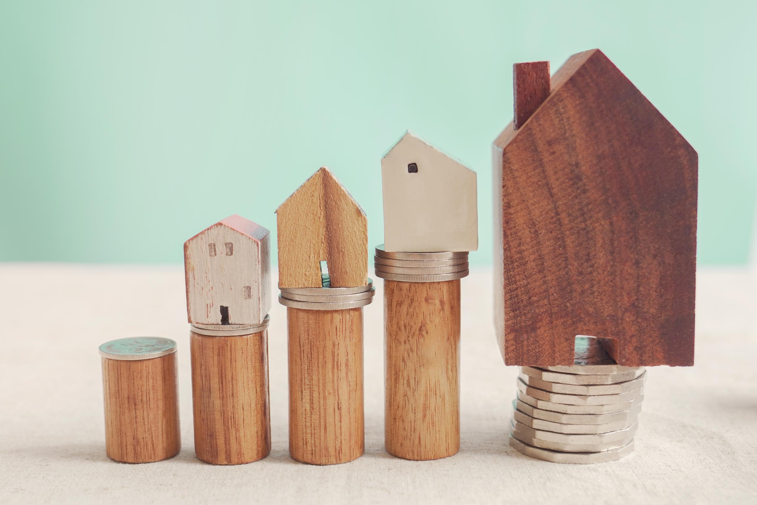 wooden houses sat atop stacks of coins