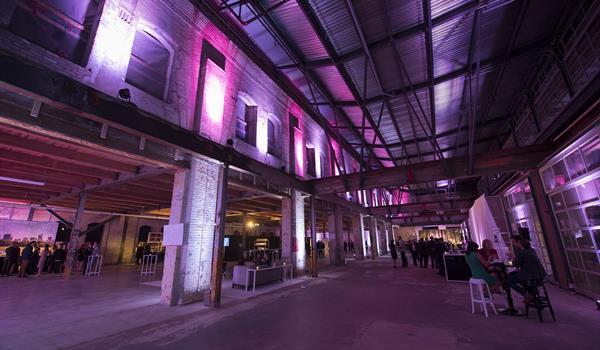 a sprawling former factory with high ceilings, exposed brick and beam, being used for a party in 2016